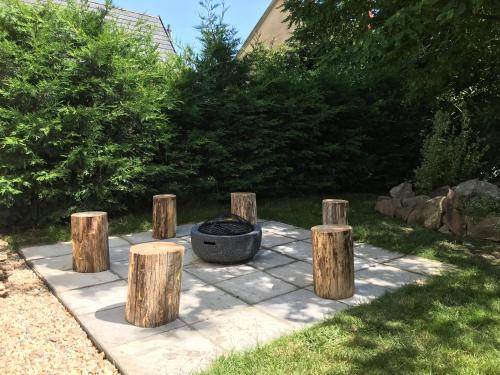 a fire pit in a garden with wooden stumps at Hívlak vendégházak in Demjén