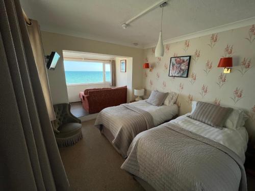 a bedroom with two beds and a view of the ocean at Navigator Hotel in Bognor Regis