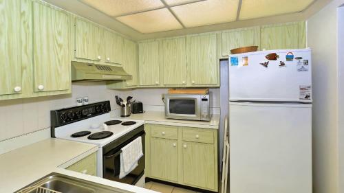 a kitchen with a white refrigerator and a microwave at 6415 Midnight Pass #307 in Siesta Key
