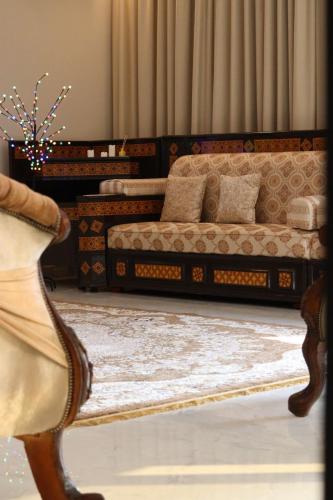 استراحة الغيل صحار : غرفة معيشة بها سريرين وأريكة