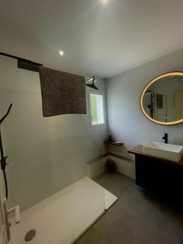une salle de bain avec un lavabo et un miroir dans l'établissement Maison à biscarrosse avec piscine et jacuzzi, à Biscarrosse