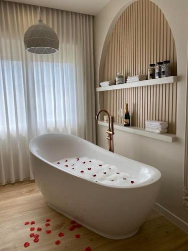 a white bath tub sitting in a bathroom at Comfort Apartament 27 in Durrës