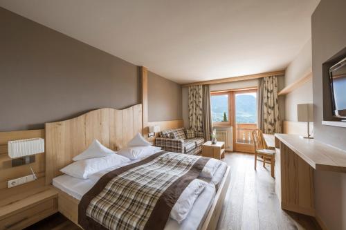 een hotelkamer met een bed en een bureau bij Landsitz Stroblhof in Tirolo