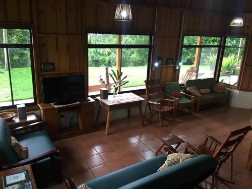 a living room with a couch and a tv at Birds & Breakfast Costa Rica in Fortuna