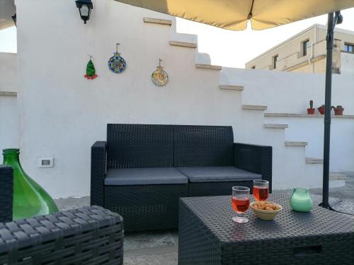 a patio with a chair and two glasses on a table at AREMU in Lecce