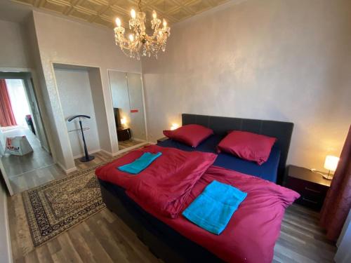 a bedroom with a large bed with red and blue sheets at Studio 50 qm zentral in Domnähe in Cologne