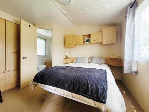 a bedroom with a large bed and a bathroom at Kingfisher Corner in South Cerney