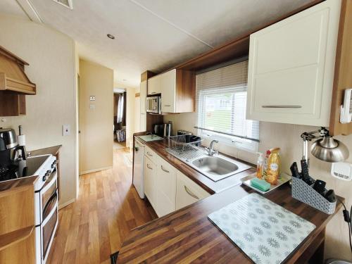 a kitchen with white cabinets and a sink at Kingfisher Corner in South Cerney