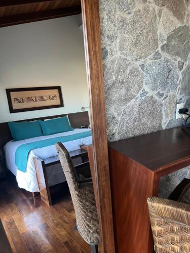 a bedroom with a bed and a table and chairs at Bemar Carmelo Hotel in Carmelo