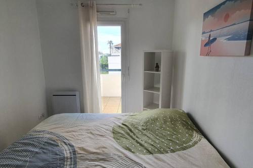 une chambre blanche avec un lit et une fenêtre dans l'établissement Le Paisible YourHostHelper, à Bayonne