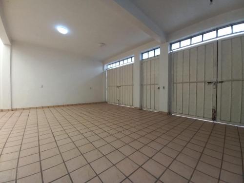 an empty garage with four doors and a tiled floor at Casa Entera Gran Descanso - Wifi in Apizaco