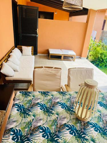 a patio with two chairs and a table and a couch at 20 steps from the beach VILLINO STECU in Costa Rei