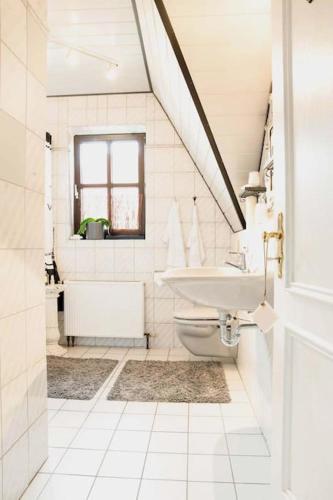 a white bathroom with a sink and a toilet at La belle etage in Coesfeld