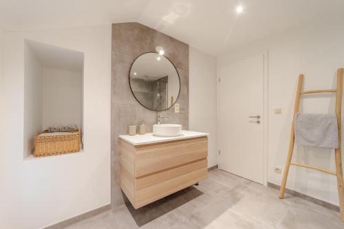La salle de bains est pourvue d'un lavabo et d'un miroir. dans l'établissement Coo'sy, proche de la cascade de Coo, à Stavelot