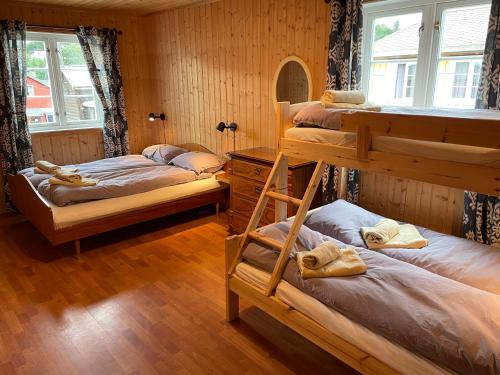 勒羅斯的住宿－Kjerkgata 6 - midt i Røros sentrum，客房设有三张双层床和一扇窗户。