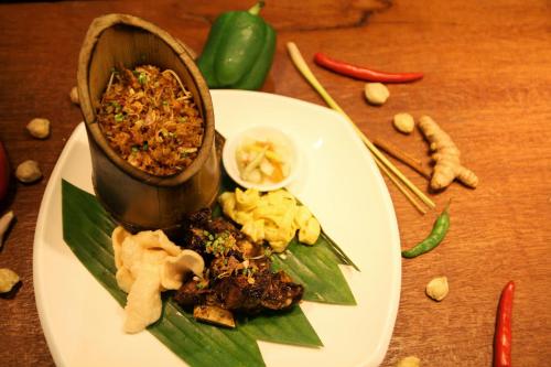a plate of food on a table with food on it at Varna Culture Hotel Soerabaia in Surabaya