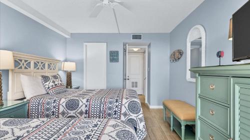 a bedroom with blue walls and a bed and a dresser at 6415 Midnight Pass #707 in Siesta Key