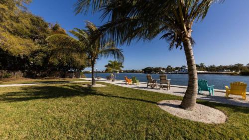 a park with chairs and palm trees next to the water at 6415 Midnight Pass #707 in Siesta Key