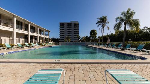 a large swimming pool with chairs and a building at 6415 Midnight Pass #707 in Siesta Key