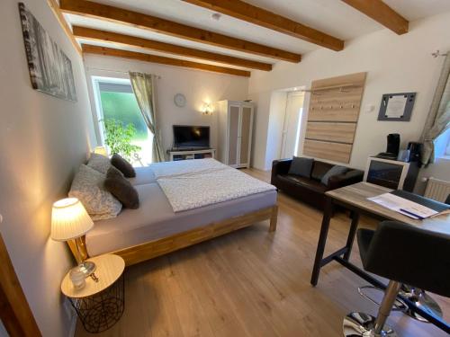 a bedroom with a bed and a living room at Großes Doppelzimmer mit eigenem Bad und Kühlschrank, frisch saniert in Friedrichskoog
