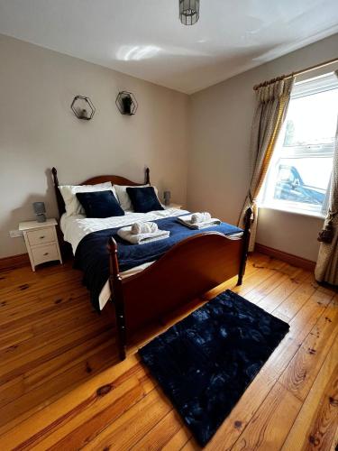 a bedroom with a bed with blue sheets and a window at Slieve Gullion Valley View in Camlough
