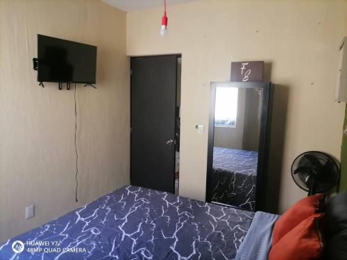 a bedroom with a bed and a flat screen tv at Casa Noria in Tepic