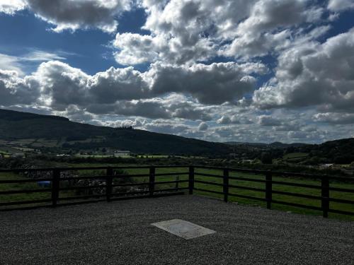 a cloudy sky with a fence and a field at Slieve Gullion Valley View in Camlough