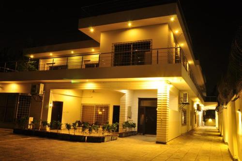 a white house with a balcony at night at Reina Boutique Hotel - G6 in Islamabad