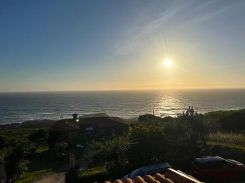 a view of the ocean from a house with the sunset at Aloxamento A Mariña in Oia