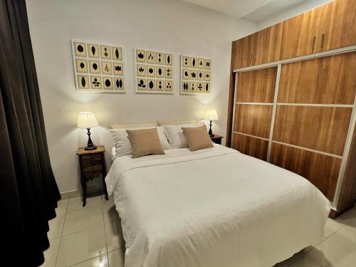 ein Schlafzimmer mit einem großen weißen Bett und zwei Lampen in der Unterkunft High Flyer KLIA at Alanis Residence Kota Warisan in Sepang