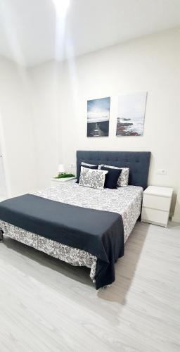 a bedroom with a bed with a black and white comforter at Apartamento Plaza Calzada 1 in Sanlúcar de Barrameda