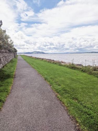 a path next to a body of water at Buncrana Beach House by Wild Atlantic Wanderer in Buncrana