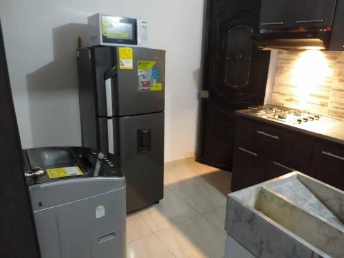 een keuken met een zwarte koelkast en een tv. bij APARTESTUDIO ALCALA ENVIGADO, CERCA A C.C VIVA . in Envigado