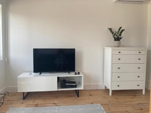 uma sala de estar com uma cómoda branca e uma televisão em Casa da Varina em Torreira