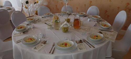 a white table with bowls of food on it at Dom Gościnny Liść Dębu 