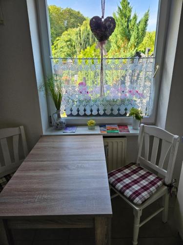 ein Fenster mit einem Tisch und Stühlen in einem Zimmer in der Unterkunft Ferienwohnung 1 Am Park in Divitz