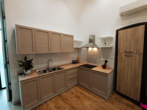a kitchen with wooden cabinets and a sink in it at Suites Elifani in Trani