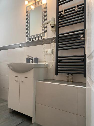 ein weißes Badezimmer mit einem Waschbecken und einem Spiegel in der Unterkunft Pension MonaLisa in Bernkastel-Kues