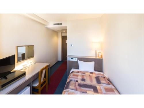 a hotel room with a bed and a desk at Sunrise Inn - Vacation STAY 75396v in Kaizuka