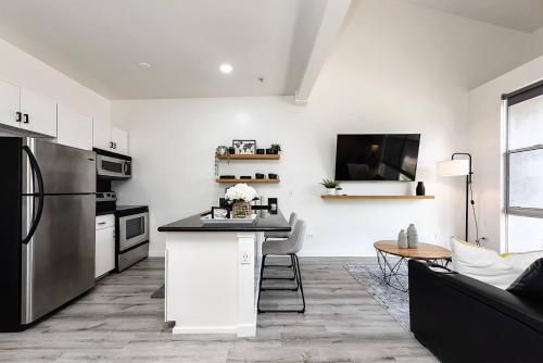 a kitchen and living room with a refrigerator and a table at Luxurious Condo Walking Distance to San Diego Bay! in San Diego