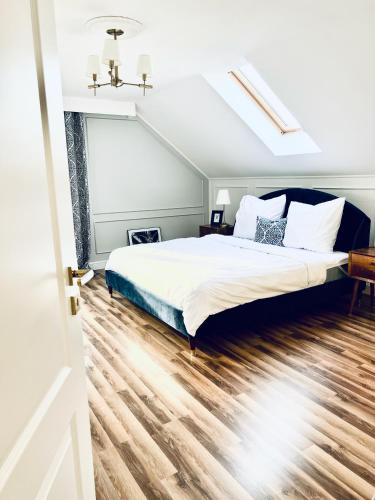 a bedroom with a bed and a wooden floor at Apartament pod Kasztanem in Lębork