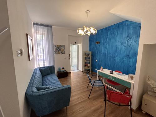 sala de estar con sofá y pared azul en La Casa di Matilde, en Barcellona-Pozzo di Gotto