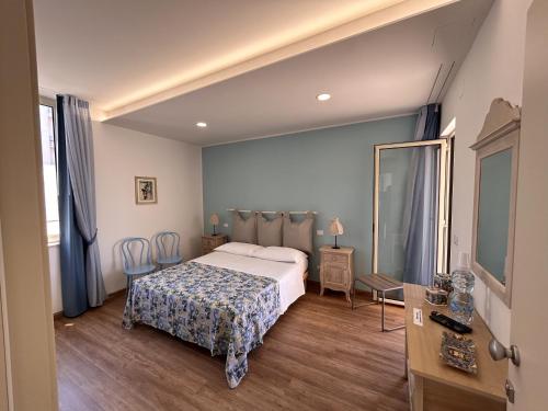 Habitación de hotel con cama y espejo en La Casa di Matilde, en Barcellona-Pozzo di Gotto