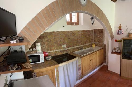 an archway in a kitchen with a sink and a microwave at A Ca’ da Zia in Corte