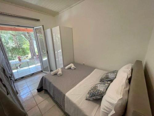 a bedroom with a bed and a large window at Villa Penelope in Corfu Town