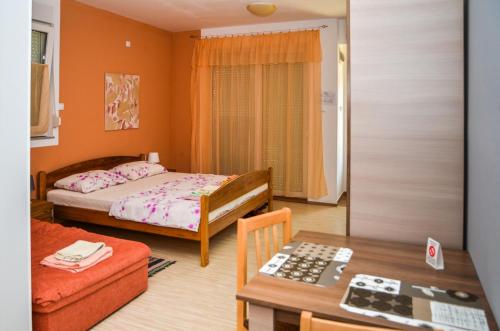 a small room with two beds and a table at Apartments Svetlica in Bački Petrovac