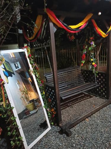 a mirror with a reflection of a bench in a yard at Hostel Lumaria 1 in Blumenau
