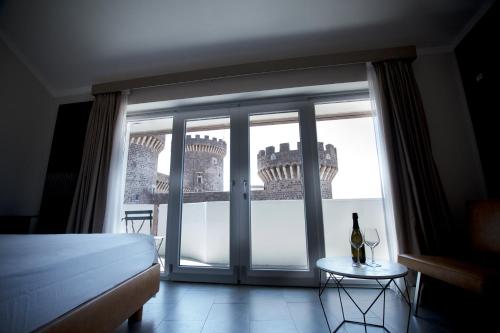 een slaapkamer met een bed en een raam met een wijnfles op een tafel bij THE APARTMENT Top Floor in Tivoli