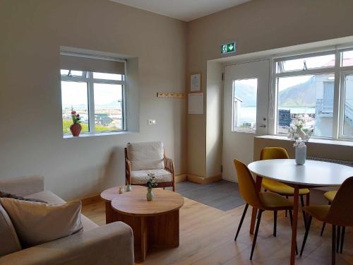 een woonkamer met een bank en een tafel en stoelen bij Gistiheimilið Bergistangi 2 in Norðurfjörður