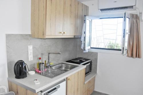 a small kitchen with a sink and a microwave at MNS Marvelous Nirvana Seascape, Creativity in Perani